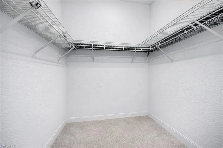 Walk in closet featuring light carpet