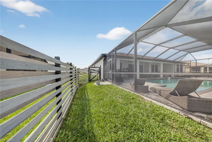 Fenced backyard featuring a sunroom, an outdoor pool, a lanai, and a patio