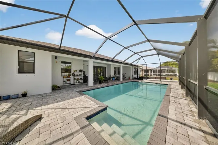 Outdoor pool featuring a patio, a sunroom, and a lanai