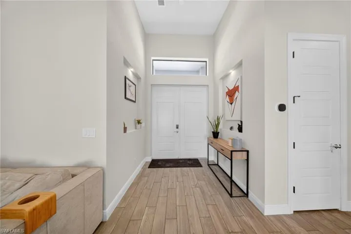 Foyer with wood tiled floors and a high ceiling