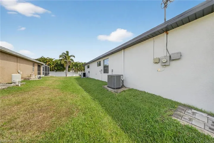 View of grassy yard featuring a sunroom