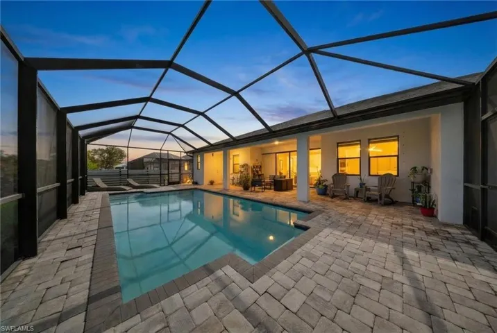 Outdoor pool with a lanai, a sunroom, and a patio