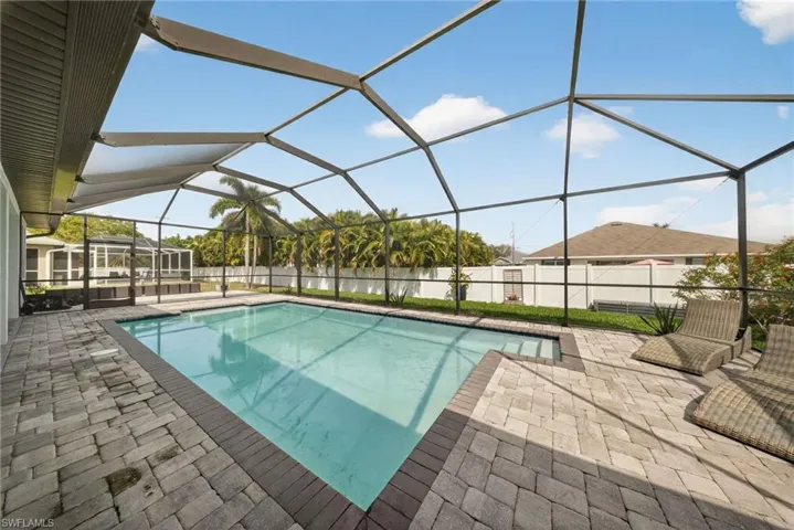 View of pool with a sunroom, glass enclosure, patio surround, and a fenced backyard