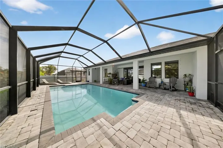 Outdoor pool featuring a sunroom, a lanai, and a patio