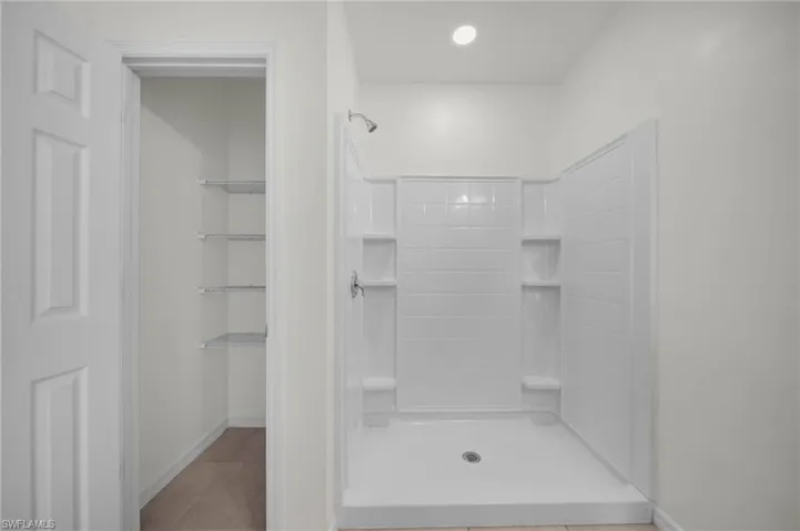 Full bathroom with a shower stall and light tile patterned flooring
