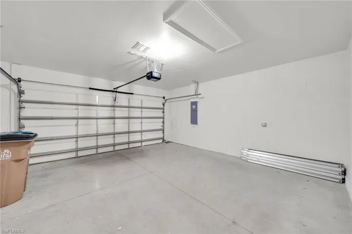 Garage featuring electric panel and a garage door opener