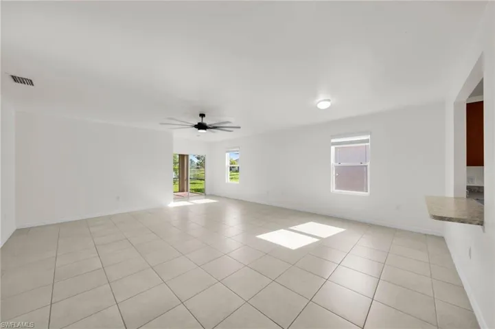 Empty room featuring light tile patterned floors and a ceiling fan