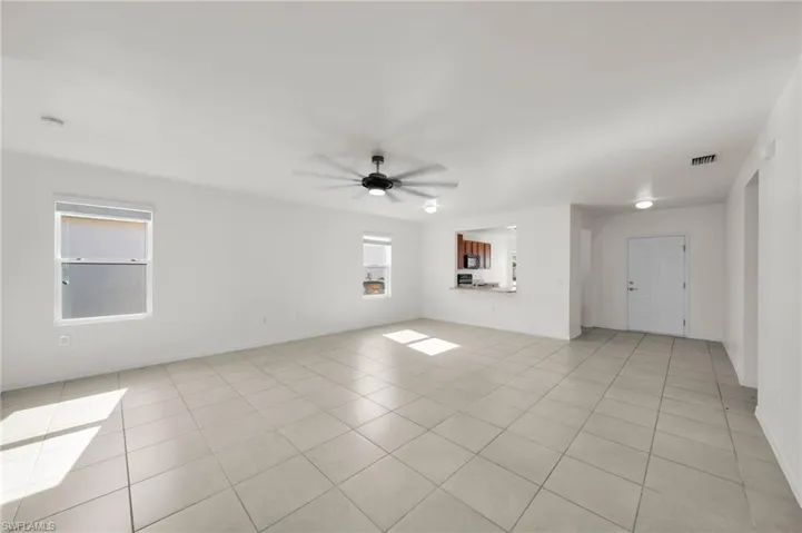 Unfurnished room with ceiling fan and light tile patterned floors