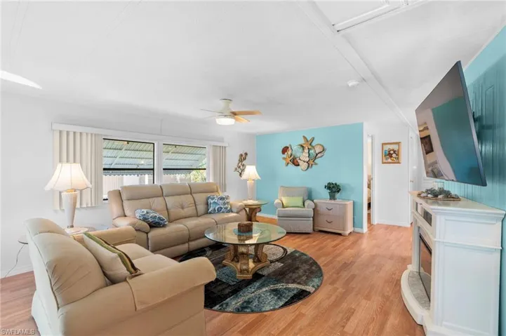 Living room with ceiling fan and light wood-type flooring