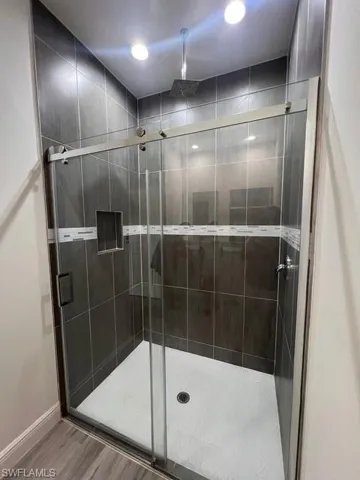 Full bathroom with a shower stall and wood finished floors