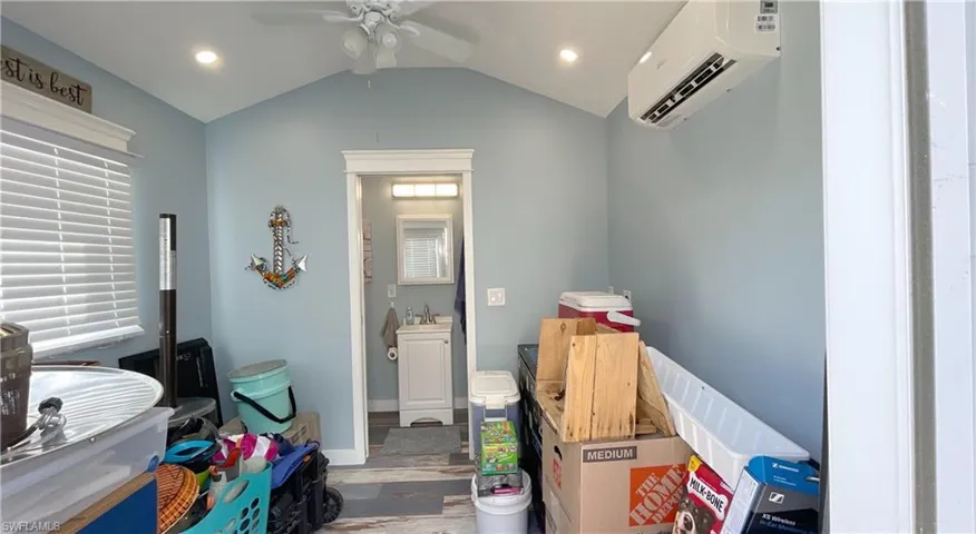 Storage with ceiling fan, sink, and a wall mounted air conditioner