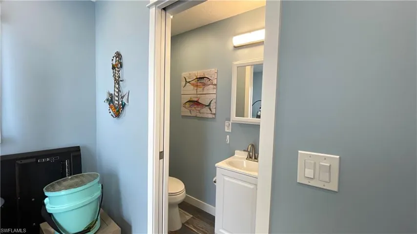 Bathroom with hardwood / wood-style floors, vanity, and toilet