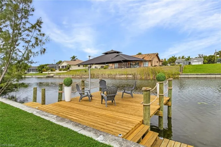 View of dock featuring a yard, a water view, a seating area.