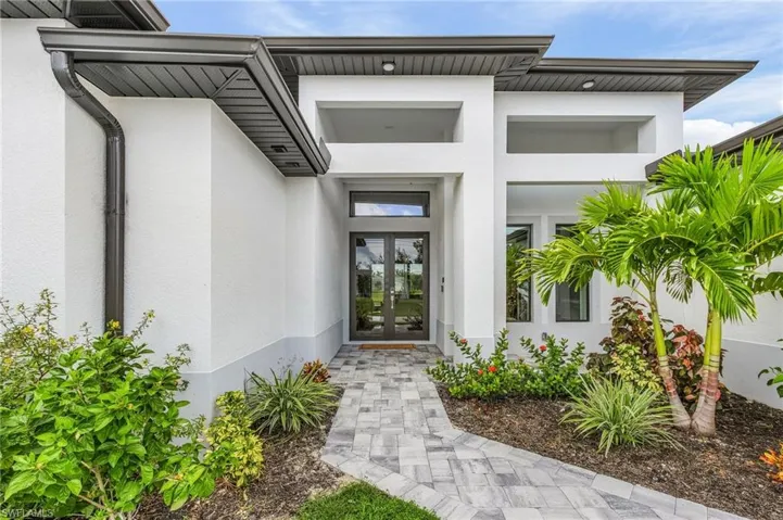 Property entrance featuring french doors and stucco siding.