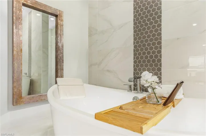 Full bathroom with a tub and recessed lighting.