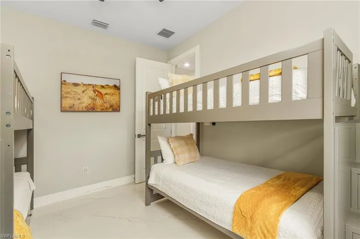 Bedroom 3 with baseboards, marble finish floor, and visible vents.