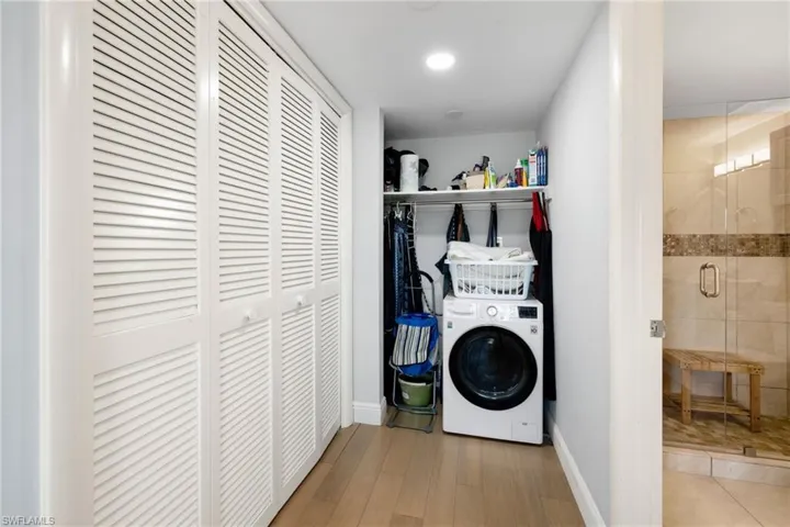 Laundry area with washer / dryer and wood finished floors