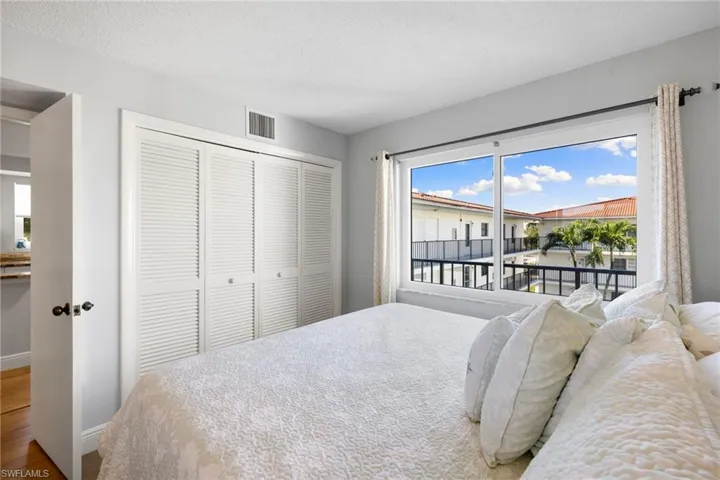 Bedroom with a closet, a textured ceiling, and wood finished floors