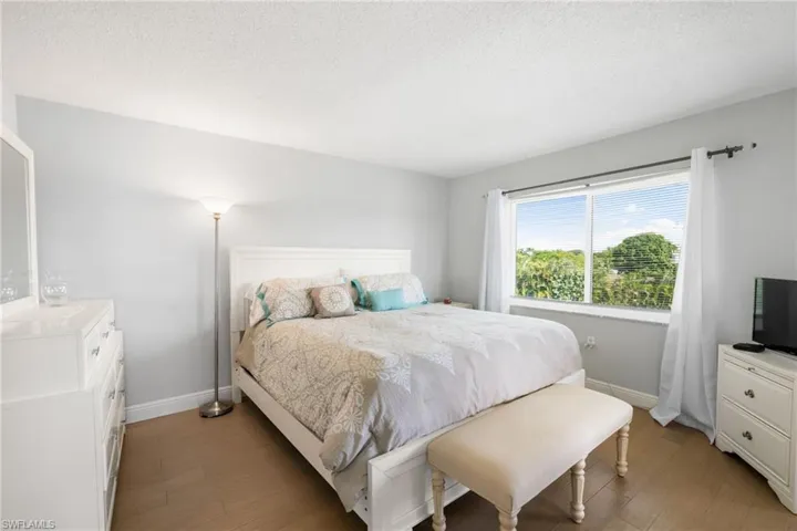 Bedroom with wood finished floors and a textured ceiling