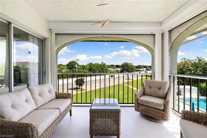 Balcony with view of pool and an outdoor hangout area