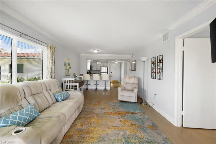 Living room featuring ornamental molding, wood finished floors, and a textured ceiling