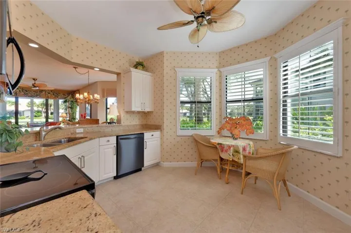 Kitchen featuring  range, stainless steel dishwasher, white cabinets, and light tile floors