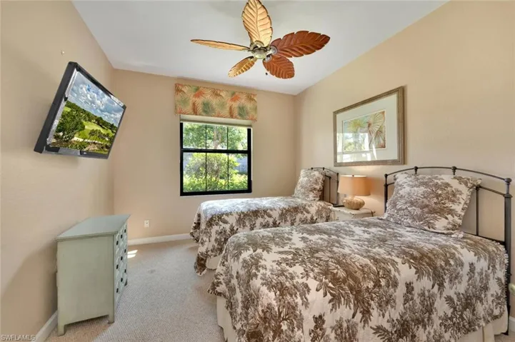 Bedroom with ceiling fan and light carpet
