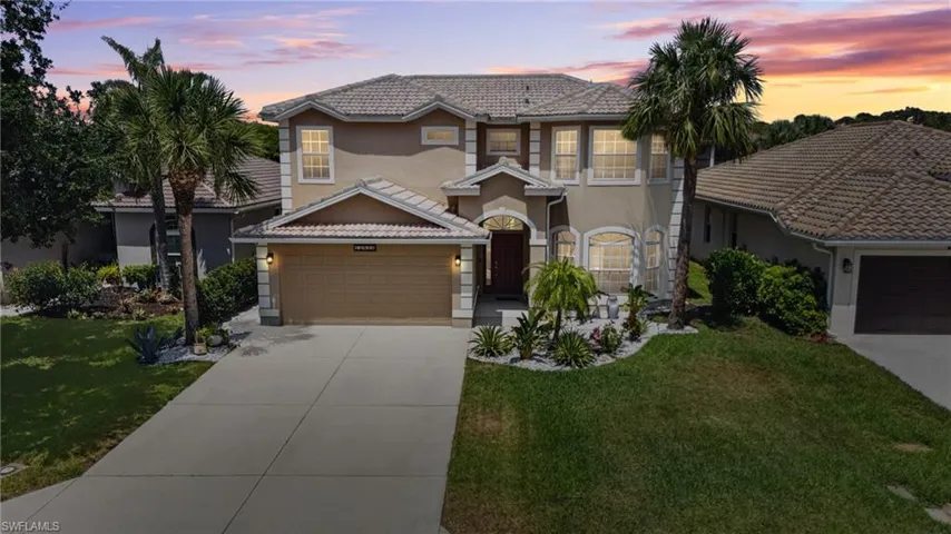 View of front of home featuring driveway, stucco siding, a tile roof, and a front lawn