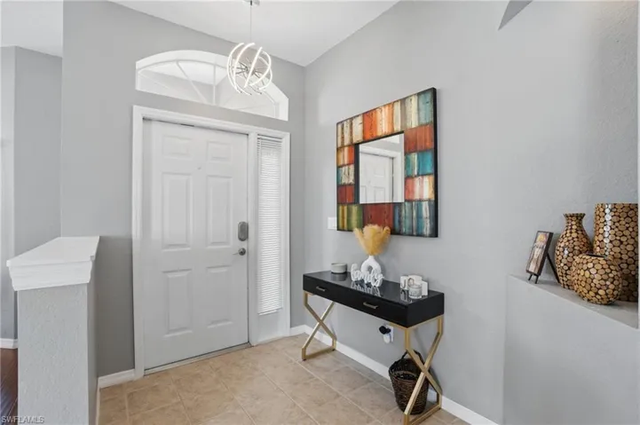 Foyer entrance featuring baseboards and a notable chandelier