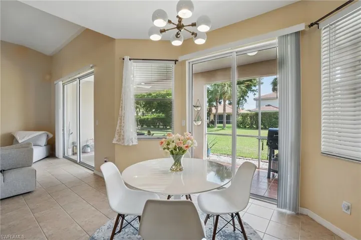 Dining space featuring light tile patterned floors, a notable chandelier, and baseboards