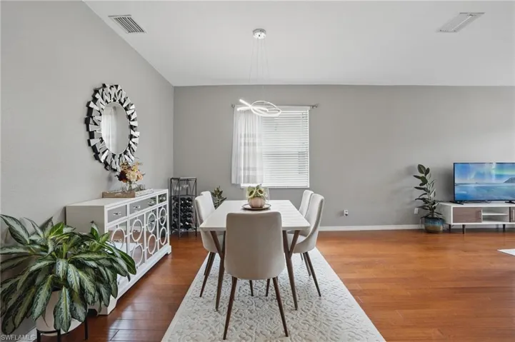 Dining area with visible vents, wood finished floors, and baseboards