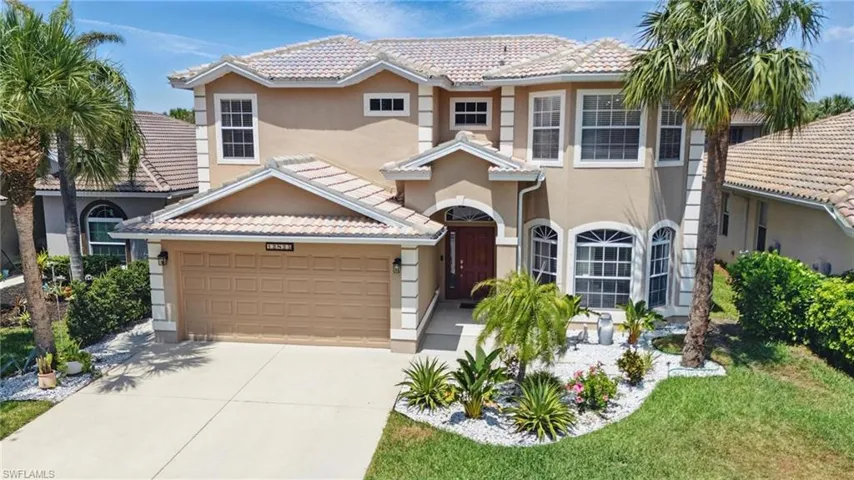 Traditional-style home with concrete driveway, stucco siding, a tiled roof, and an attached garage