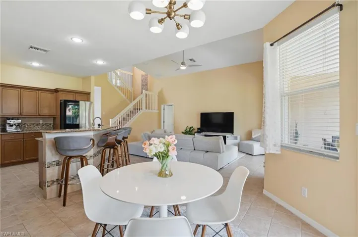 Dining room featuring recessed lighting, baseboards, visible vents, light tile patterned flooring, and stairway