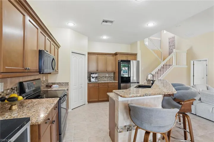Kitchen featuring a sink, tasteful backsplash, visible vents, open floor plan, and appliances with stainless steel finishes