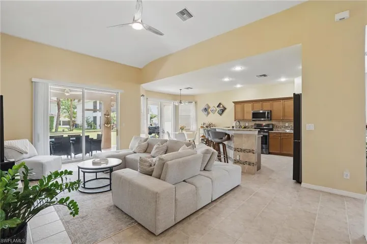 Living room featuring light tile patterned floors, ceiling fan, and visible vents