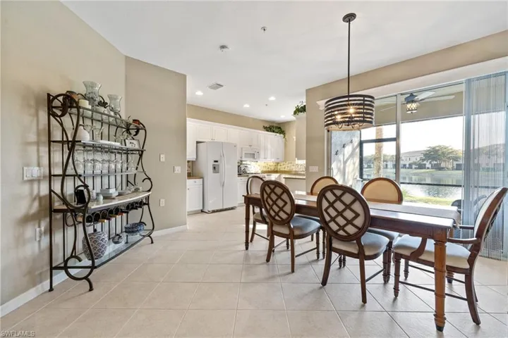 Tiled dining space featuring a water view and ceiling fan