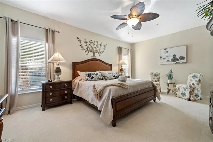 Carpeted main bedroom featuring ceiling fan
