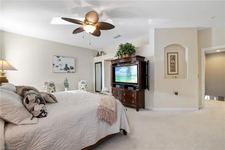 Carpeted main bedroom with ceiling fan