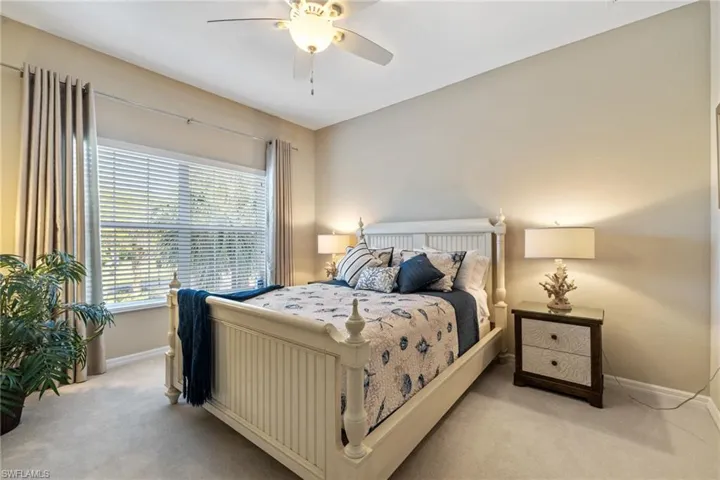 Bedroom with ceiling fan and light carpet