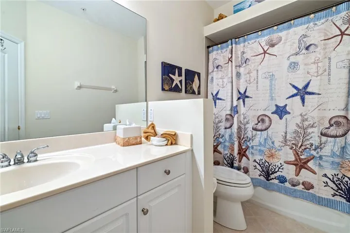 Full bathroom featuring tile patterned floors, toilet, shower / tub combo, and vanity