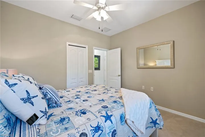 Bedroom featuring light colored carpet, ceiling fan, and a closet