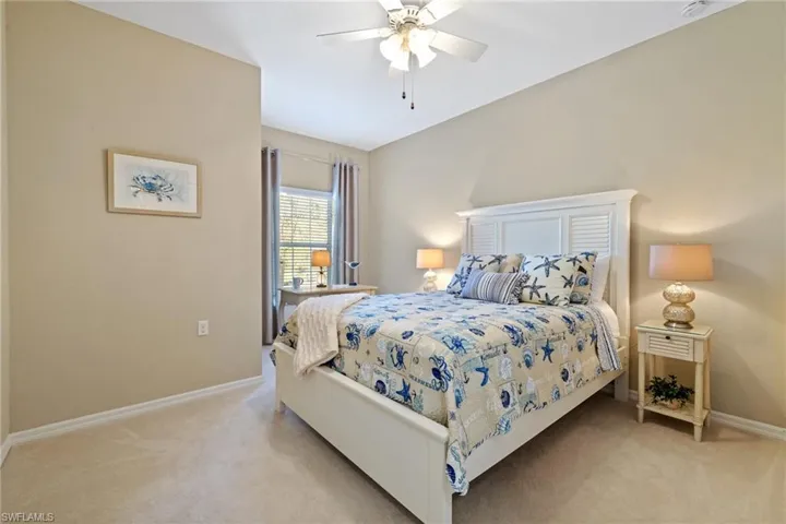 Carpeted bedroom featuring ceiling fan