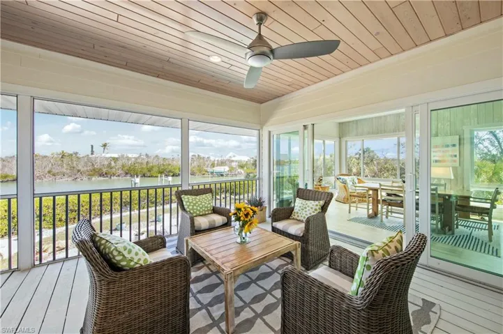Sunroom featuring a water view, ceiling fan, and wooden ceiling