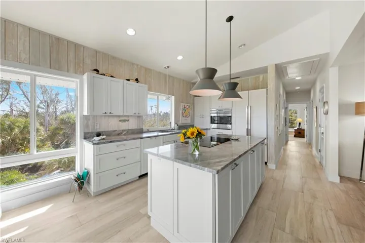 Kitchen featuring a center island, hanging light fixtures, and white cabinets