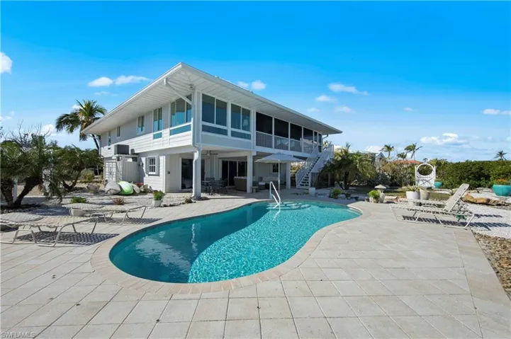View of swimming pool with a patio area and a sunroom