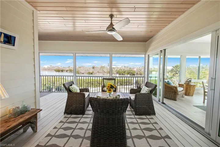 Sunroom with a water view, wooden ceiling, and ceiling fan