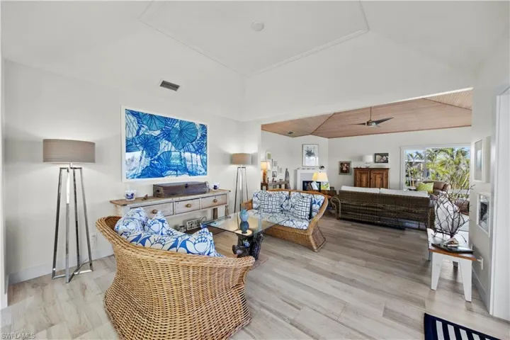 Living room featuring ceiling fan, high vaulted ceiling, and light hardwood / wood-style floors