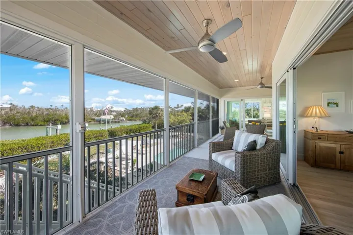 Sunroom featuring wood ceiling, ceiling fan, and a water view