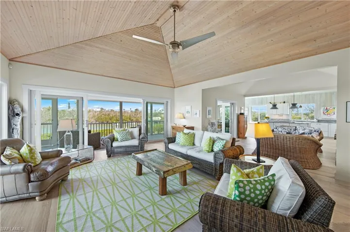 Living room with ceiling fan, light hardwood / wood-style flooring, high vaulted ceiling, and wooden ceiling
