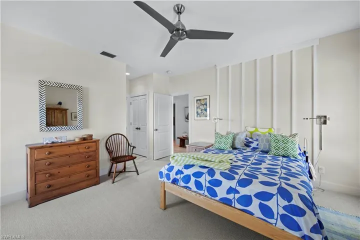 Carpeted bedroom featuring ceiling fan